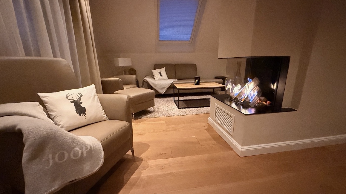 Wohnzimmer HarzElegance Walkenried mit Kaminatmosphäre am Abend – romantisch für Paare